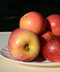 Manzanas royal gala ecológicas sobre plato blanco