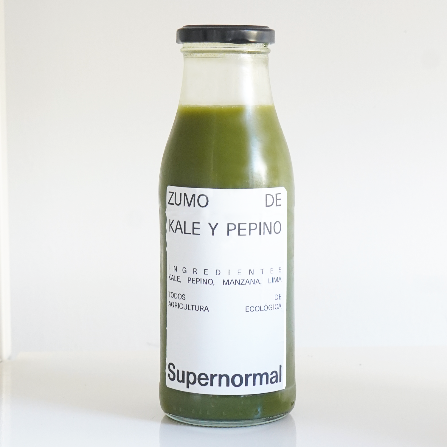 Botella de cristal con tapa negra de zumo de kale y pepino ecológico